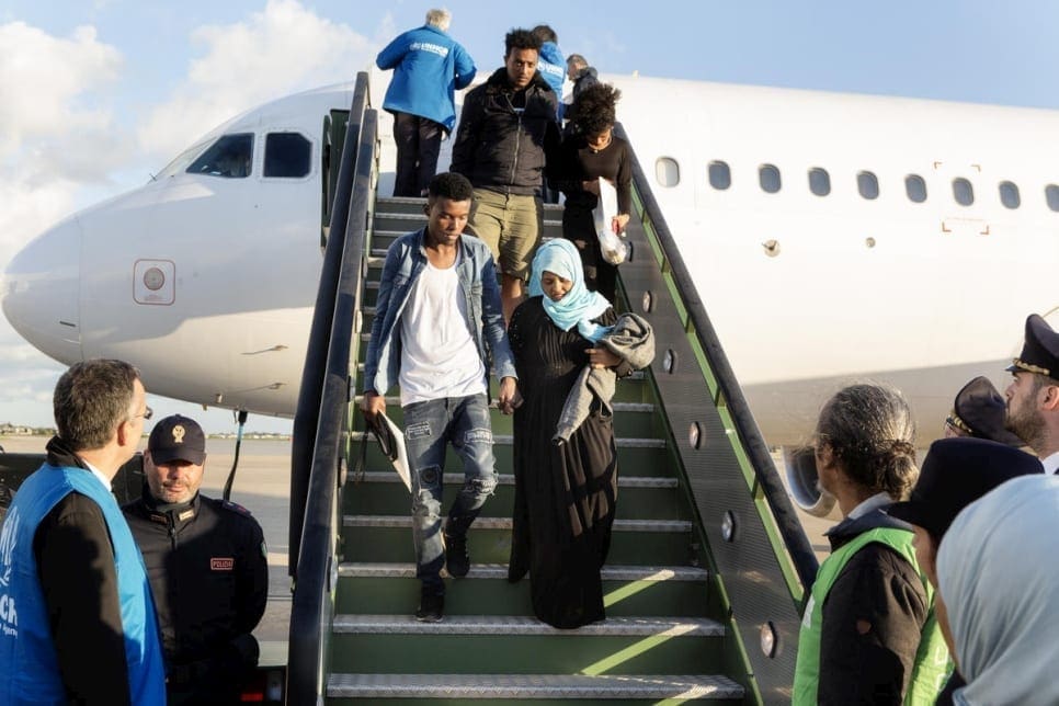 لاجئون ينزلون من رحلة إجلاء من ليبيا بعد هبوطهم في قاعدة براتيكا دي ماري الجوية في إيطاليا، في 29 أبريل ( مفوضية شؤون اللاجئين)